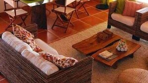 A cozy living room with a dining table, wicker sofa, and a coffee table.