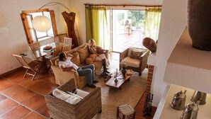 A cozy living room with a sofa set, a wicker chair, and a coffee table.