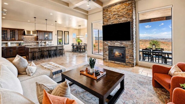 A spacious living area with a fireplace, a large TV, and a view of the desert. - The Overlook - Triple Primary Luxe, 50 Mile Views (Page)