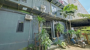 A building with multiple air conditioning units, a covered entrance, and several potted plants. - OYO Life 2928 Rumah Ceria (Semarang)
