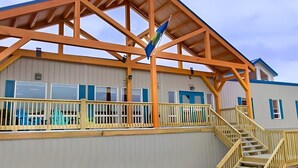 A building with a wooden structure, a staircase, and a flag. - Target Hospitality-Cheecham Lodge (Janvier South)