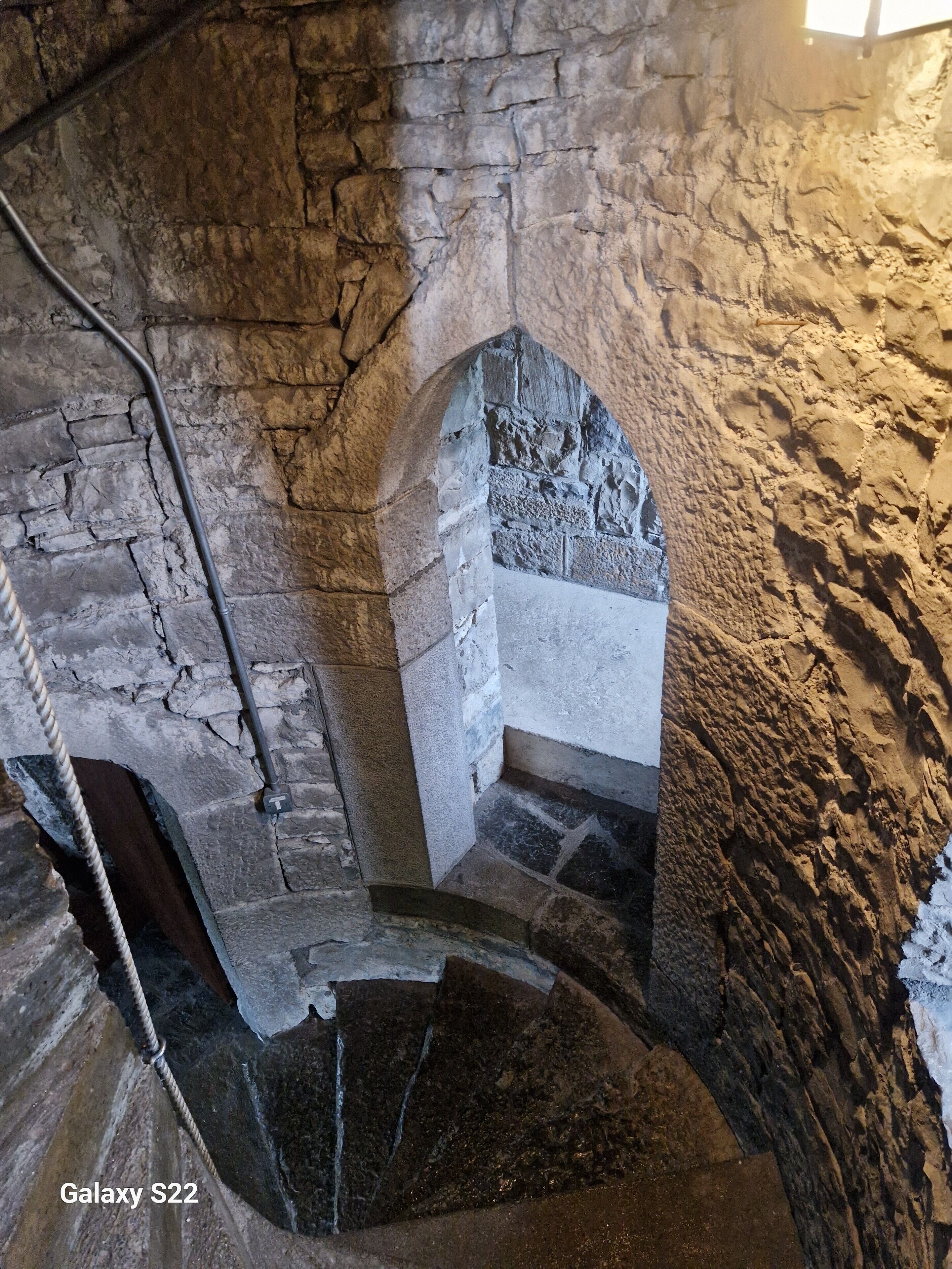A stone staircase with a narrow passageway and a small alcove.