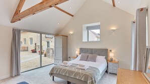 Een slaapkamer met een bed, nachtkastjes, een raam en uitzicht.