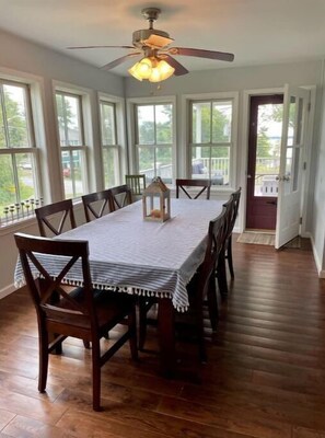 Enjoy meals with family and friends at this dining room, featuring a spacious table for six and a beautiful view of the outdoors.