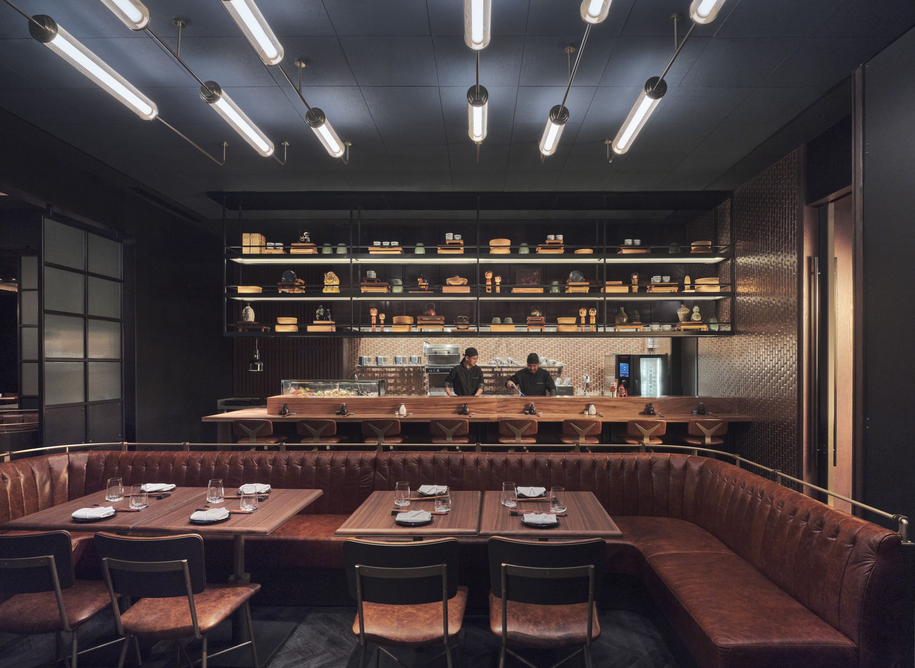 A restaurant with a bar area, booths, and a counter with staff.