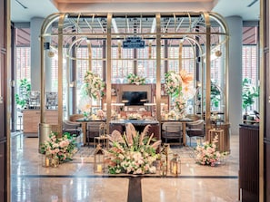 A reception area with a modern design, featuring a central desk, seating area, and decorative floral arrangements. - Pullman Singapore Hill Street (Singapore)