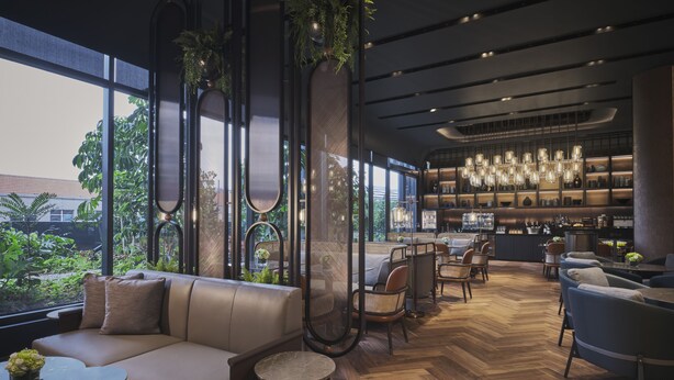 A modern interior with a large window, a bar area, and seating arrangements. - Pullman Singapore Hill Street (Singapore)