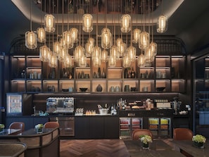 Un espace bar avec des luminaires suspendus, des étagères remplies de bouteilles et un comptoir.