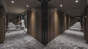 A long, narrow hallway with a stone-patterned floor and dark wooden paneling on the walls. - Pullman Singapore Hill Street (Singapore)