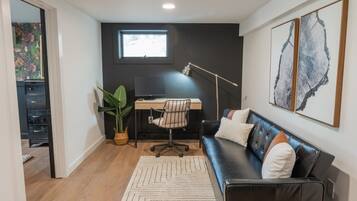 A modern room with a desk, chair, and sofa.