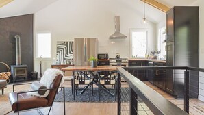 A modern kitchen with a central island, stainless steel appliances, and a large refrigerator. - Mossy Moody Cabin in High Falls, NY (High Falls)