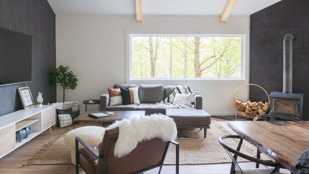 A modern living room with a large window, a fireplace, and a cozy seating area. - Mossy Moody Cabin in High Falls, NY (High Falls)