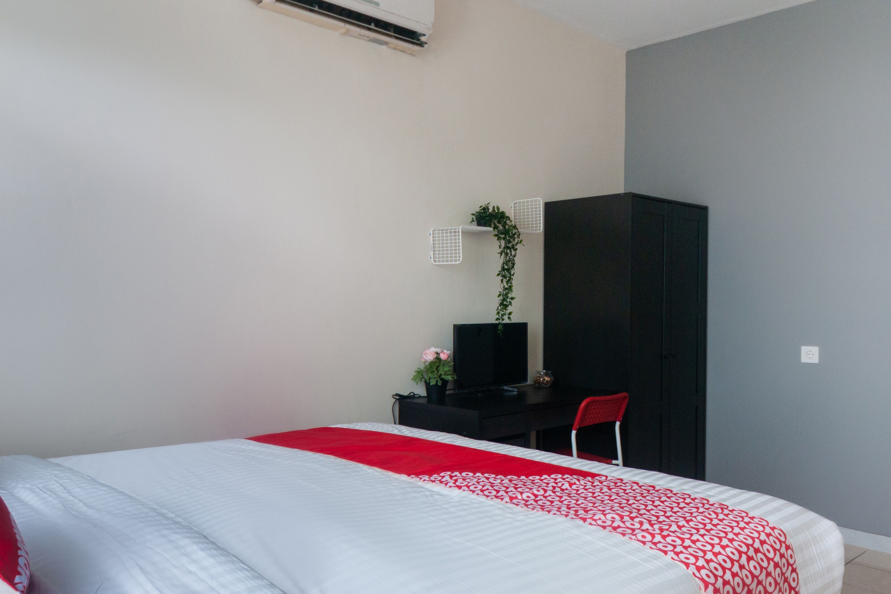 A bedroom with a bed, a desk, a chair, and a wardrobe.