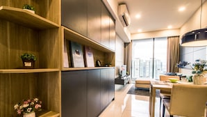 Un salon moderne comprenant un coin repas, des étagères en bois et une grande fenêtre donnant sur la ville.