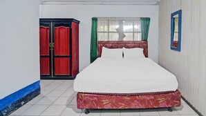 A bedroom with a bed, a wardrobe, a window with curtains, and a mirror. - SPOT ON 92278 Hotel Vorel (Tondano)