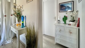 Una habitación bien iluminada con un escritorio blanco, un aparador blanco y un cuadro en la pared.