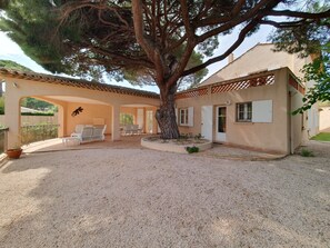 A house with a covered patio, a large tree, and outdoor seating. - LA GRANDE PINÈDE (Sainte-Maxime)