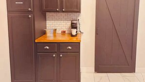 Una cocina con armarios de madera oscura, encimera de madera y una cafetera.