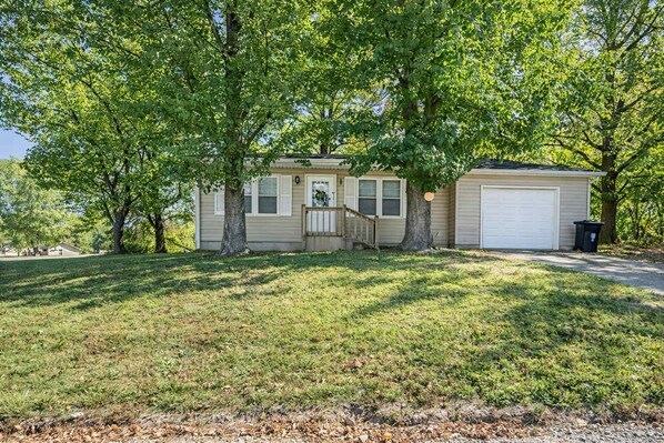 A single-story house with a front porch, a garage, and a well-maintained lawn.