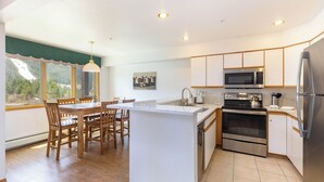 A modern kitchen with wooden cabinetry, a built-in oven, a microwave, and a refrigerator. - Panoramic Mountain Views/Hot Tub Access/Private Deck with Grill (Keystone)
