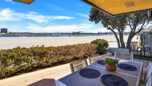 A terrace with a view of the beach, outdoor seating, and a potted plant. - Baybreeze-3bd, 2ba, sleep 8 (San Diego)