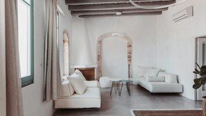 A modern living room with a white sofa, a small round table, and a fireplace.