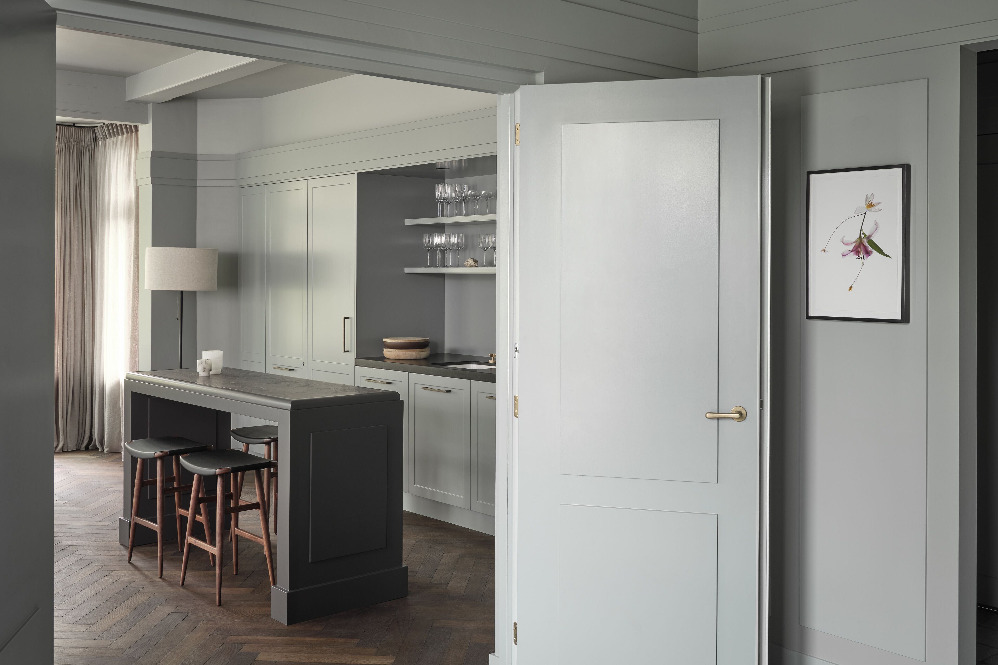 Una cocina moderna con una isla central, taburetes de bar y un comedor.