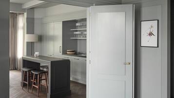 Una cocina moderna con una isla central, taburetes de bar y un comedor.