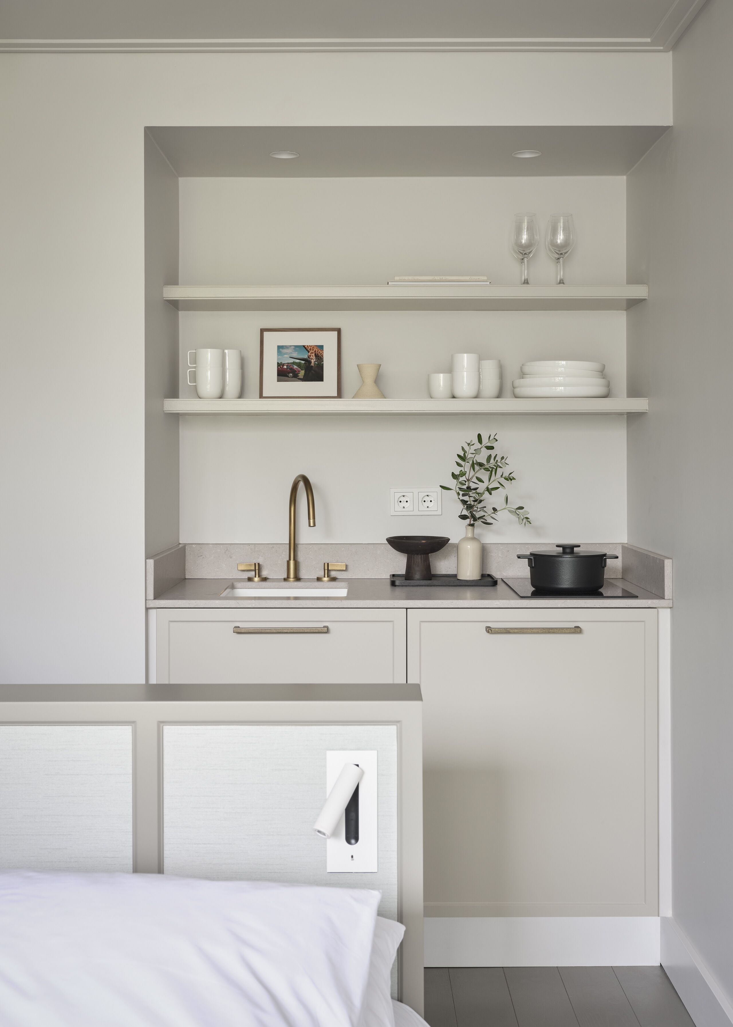 Una cocina moderna con armarios blancos, una isla central y un horno empotrado.