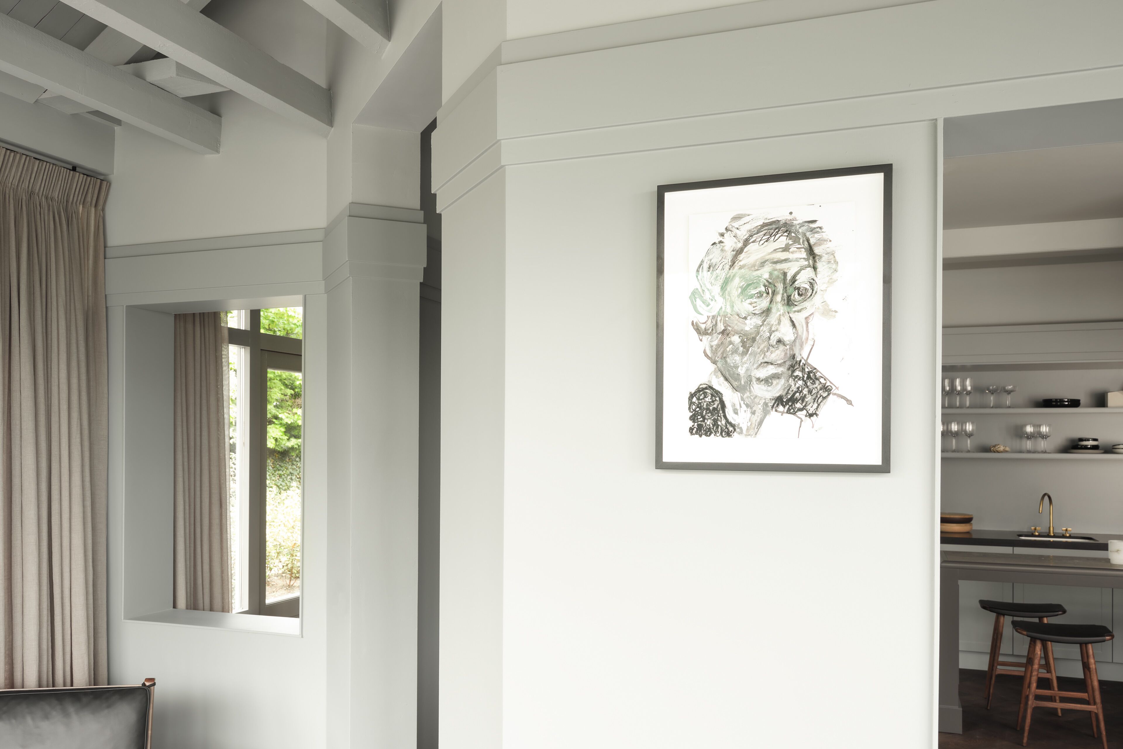 Une cuisine moderne avec une fenêtre, une œuvre d’art encadrée au mur et un coin bar.