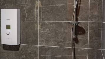 A bathroom with a shower, a toilet, and a hand dryer.
