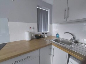 Enjoy cooking in this well-equipped kitchen with a stainless steel sink, coffee maker, and dishwasher.