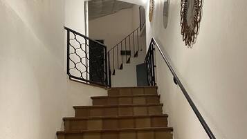 A staircase with brown tiles, a black handrail, and a decorative wall piece.