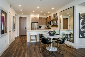 A modern kitchen with wooden cabinets, a stainless steel refrigerator, and a white island with bar stools.