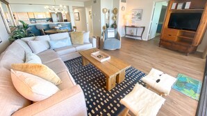 A modern living room with a sectional sofa, a wooden coffee table, and a patterned rug.
