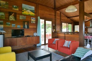Ein Holzinterieur mit Fernseher, Sofa und Essbereich.