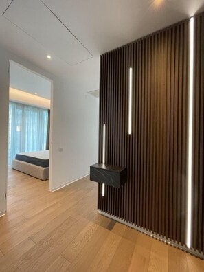 A modern room with a wooden slat wall, a built-in bench, and a small black shelf.