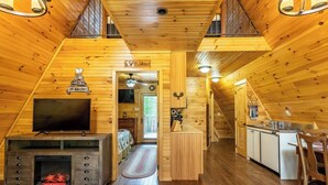 Una cabaña acogedora con televisión, chimenea y decoración de madera.