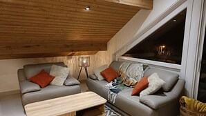 Ett mysigt vardagsrum i loftstil med två soffor, ett soffbord och en golvlampa.
