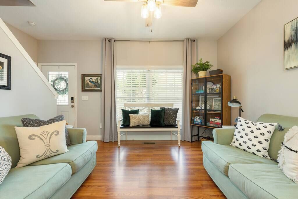 A living room with two light green sofas, a wooden bench, and a bookshelf.