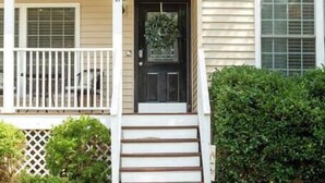 A two-story house with a front porch, a black front door, and a small front yard. - *10 Minutes to Downtown & Biltmore, Next to Parkway (Asheville)