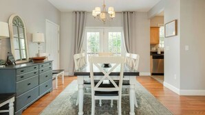 A dining area with a table set for four, a chandelier, and a view of the kitchen. - *10 Minutes to Downtown & Biltmore, Next to Parkway (Asheville)