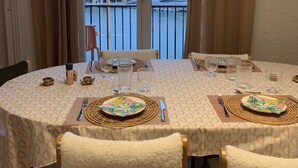 A dining area with a table set for four, overlooking a marina with boats and buildings.