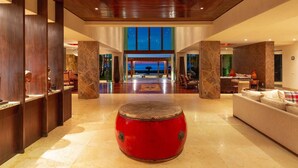 A spacious lobby with a red drum in the center, wooden pillars, and a view of the night sky through large windows. - Beachfront Villa w/ large pool, 5 huge BR's all with Ocean Views & 5-pers. staff (SAN FRANCISCO, BAHIA DE BANDERAS)