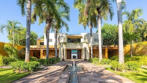 A modern resort with a central water feature, palm trees, and a well-maintained garden. - Beachfront Villa w/ large pool, 5 huge BR's all with Ocean Views & 5-pers. staff (SAN FRANCISCO, BAHIA DE BANDERAS)