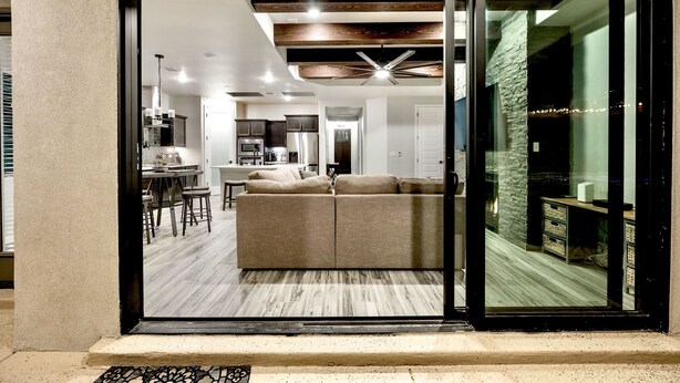 A modern interior with a sofa, dining area, kitchen, and a staircase leading to a balcony. - Modern 3-Bedroom Villa with Jacuzzi and Gym (Las Cruces)
