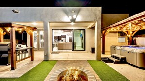A modern outdoor patio area with a fire pit, a hot tub, and a covered seating area. - Modern 3-Bedroom Villa with Jacuzzi and Gym (Las Cruces)