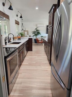 Una cocina moderna con electrodomésticos de acero inoxidable, armarios de madera y una isla central.