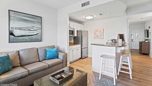 A modern apartment with a living room, kitchen, and dining area.