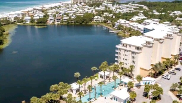 A coastal resort with a large pool, beachfront villas, and a marina.